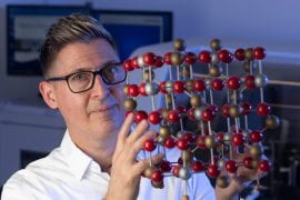 <p>David Kisailus, UCI professor of materials science and engineering, holds a model of crystal magnetite. He and his fellow researchers found that microbes living in Chile’s Atacama Desert transform magnetite to a different iron oxide phase called hematite in the process of acquiring the iron that’s necessary for their survival in a harsh environment. Steve Zylius / UCI</p>
