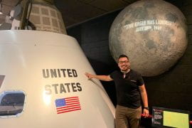 <p>José Flores-Velázquez poses with the command module from 1969’s Apollo 11 spacecraft — the first to land humans on the moon. UCI</p>

