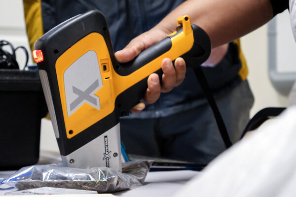 a hand-held device is used to measure lead levels in a soil sample
