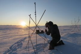 <p>Support staff at the National Science Foundation’s Toolik Field Station in Alaska exchange CO2 traps in November. The samplers consist of permanent access wells – vertical metal tubes buried in the soil at different depths – attached to exchangeable CO2 traps and are anchored into the permafrost with rebar. The Brooks Mountain Range is visible in the background. A. Young / NSF</p>
