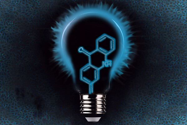 a light bulb with a chemical structure in front of an image of cells that are all blue tinged