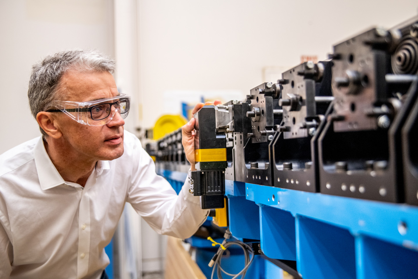<p>Left: Senior Team Lead for  Berkeley Lab LCLS-II activities, John Corlett, inspects an LCLS-II undulator in the Berkeley Lab shops. (Credit: Marilyn Sargent/Berkeley Lab).</p>
