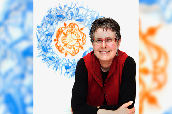 a headshot of Rebecca Kamen in front of an abstract painting