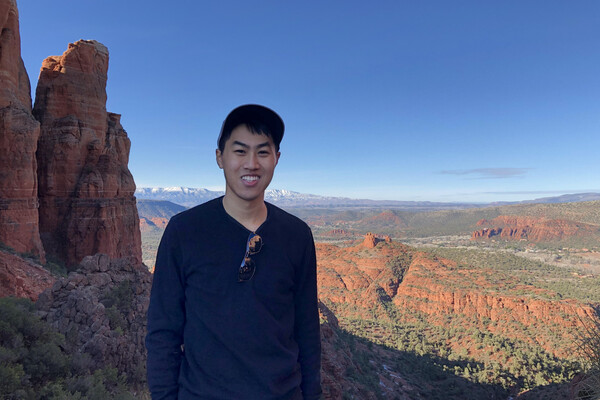 student standing outside with mountains in the background